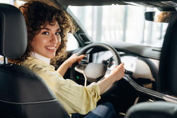 Feeling good, sitting and smiling. Happy woman is sitting in the car