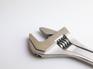 A wrench, also known as an adjustable wrench, is shown on a white background. It is a versatile tool designed for tightening or loosening bolts or nuts with adjustable jaws.