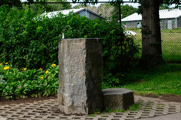 Rustic basalt water fountain surrounded by greenery in Reykjavik, Iceland outdoor setting