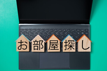 パソコンと家型のプレートとお部屋探しの文字