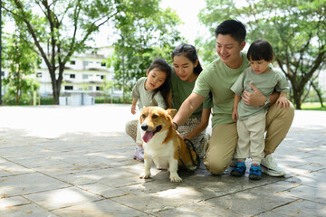 A Happy Asian Family Enjoying Urban Park Day with Their Dog