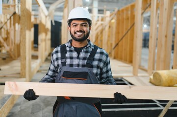 Construction of modular houses. Male indian construction worker in uniform and hard hat at...