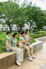A Parents and children relax with their corgi in a peaceful green park, showcasing warmth,...