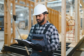 Indian carpenter works on the construction of modular houses