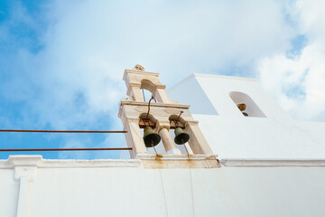 Church bell tower against blue sky in Plaka, Milos, Greece