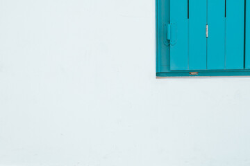 Closed blue shutter on white wall, Milos island, Greece