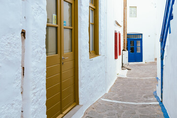 Narrow street with colorful doors in Plaka, Milos, Greece