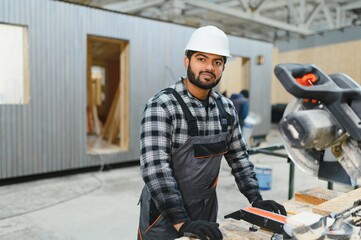 Indian carpenter works on the construction of modular houses