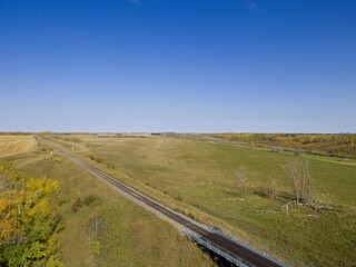 Fototapeta premium A drone captures a railway bridge over a small river in Saskatchewan.