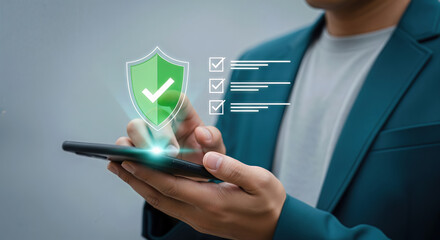 A person holds a smartphone displaying a digital shield icon with a green checkmark, indicating secure data or a verified status