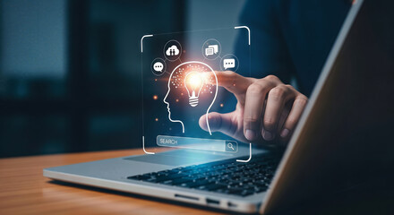 A finger touches a glowing lightbulb inside a digital head profile on a laptop screen, representing innovation and ideas