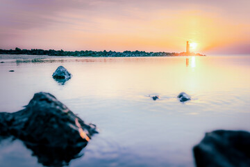 Serene Sunrise at the Coast with Distant Lightsignal