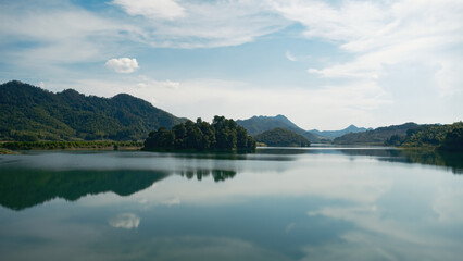 Serene lake surrounded by lush mountains under a clear sky
