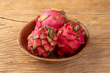 Pitayas or Dragon fruits on a bowl over wooden table