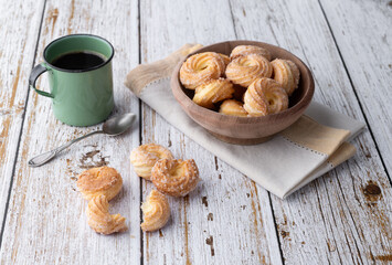 Typical brazilian sugar covered biscuit with coffee over wooden table