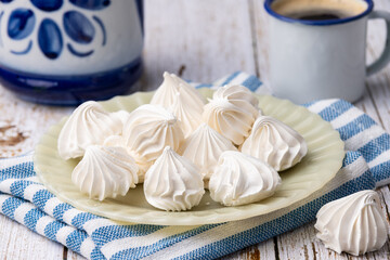 Fresh homemade meringue cookies over wooden table