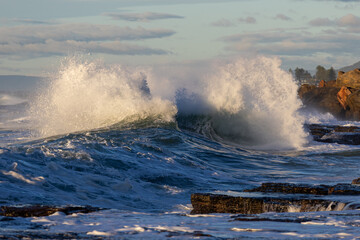 Big wave breaking on the rocky shore.