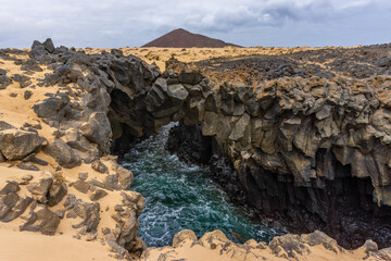Arch rock formation by the sea, Arcos de los Caletones, La Graciosa, Canary Islands