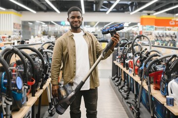 New vacuum cleaner. An African man buys a vacuum cleaner in a household goods store