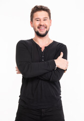 Smiling young man in casual black long sleeve shirt poses with arms crossed against a white background