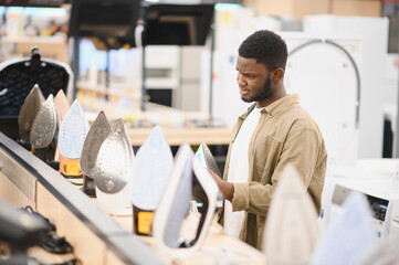 Man choosing electric iron at store