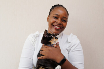 Closeup portrait, young black african American woman holding and petting adorable tabby cat at home. Positive people emotional in love pet animal, facial expression, feelings.