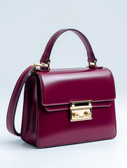 Burgundy Leather Handbag with Gold Clasp on White Background