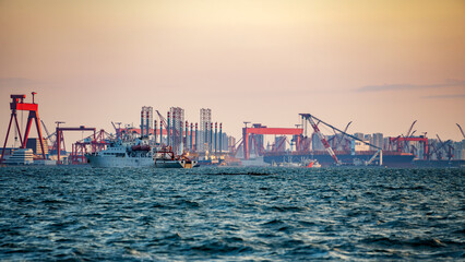Busy Port with Cranes and Vessels at Dusk