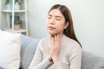 Sickness in inflaming asian young woman, girl use hand check self touch at sore throat, pain...