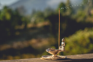 Incense Stick with Buddha Figurine at Sunrise Outdoors