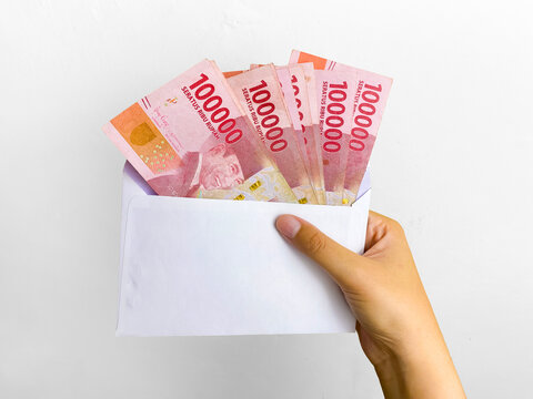 The concept of salary payments in envelopes. Indonesian rupiah currency, one hundred thousand Indonesian rupiah money.