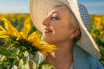 A Joyful Happy Senior Woman in a Field of Sunflowers is Celebrating the Natural Beauty Around Her