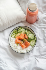 Salmon Rice Bowl with Fresh Cucumber and Juice on White Bedding