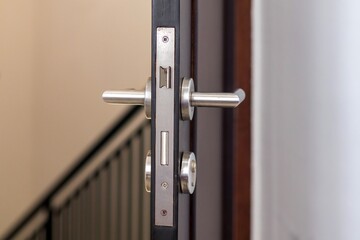 Close up view of bedroom door handle and open bedroom door