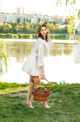 A girl in a wreath of flowers with a basket on Ivan Kupala Day.