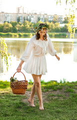 A girl in a wreath of flowers with a basket on Ivan Kupala Day.