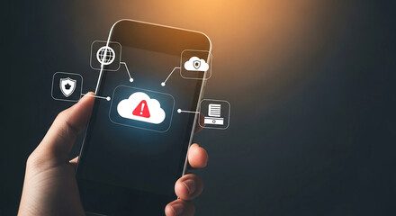 Hand holding mobile phone with warning alert icon representing cyber security risk and data breach