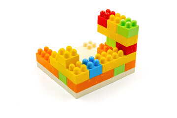Colorful plastic building blocks assembled into a structure on white background