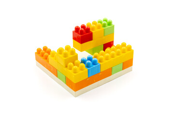 Colorful plastic building blocks assembled into a structure on white background