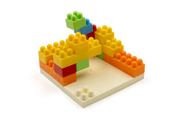 Colorful plastic building blocks assembled into a structure on white background