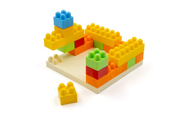 Colorful plastic building blocks assembled into a structure on white background