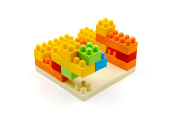 Colorful plastic building blocks assembled into a structure on white background