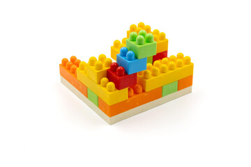 Colorful plastic building blocks assembled into a structure on white background