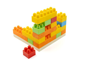 Colorful plastic building blocks assembled into a structure on white background