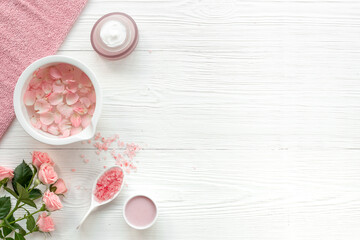 Spa organic cosmetic products with roses essential oil on white background top view