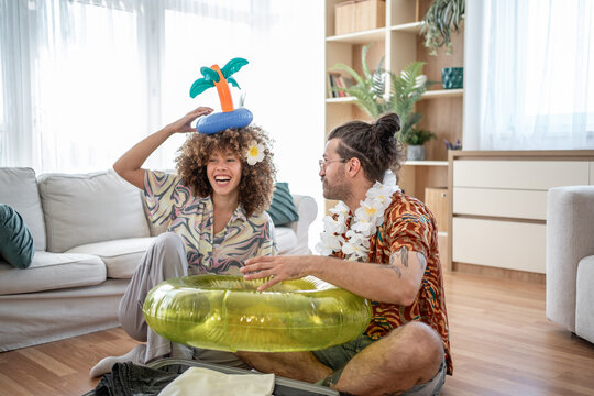 Happy couple packing inflatable toys for summer vacation - Powered by Adobe