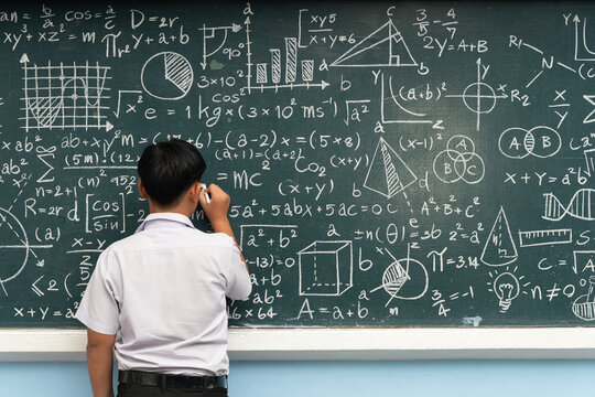 Student writing mathematical formulas on chalkboard with graphs and equations education learning concept