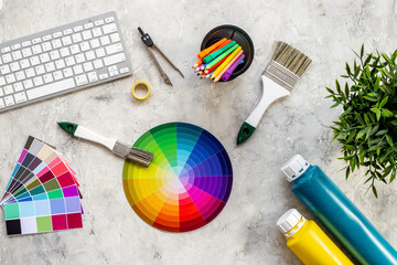 Flat lay of color paint swatches and decorator or designer tools for work on desktop, top view