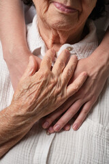 Elderlyl hand hug and young hands.  The granddaughter comforts the grandmother, the patient. Concept of support and care, love, warmth,  Mother's day, help, donate.