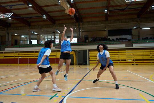 Female basketball players competing during training in gymnasium - Powered by Adobe